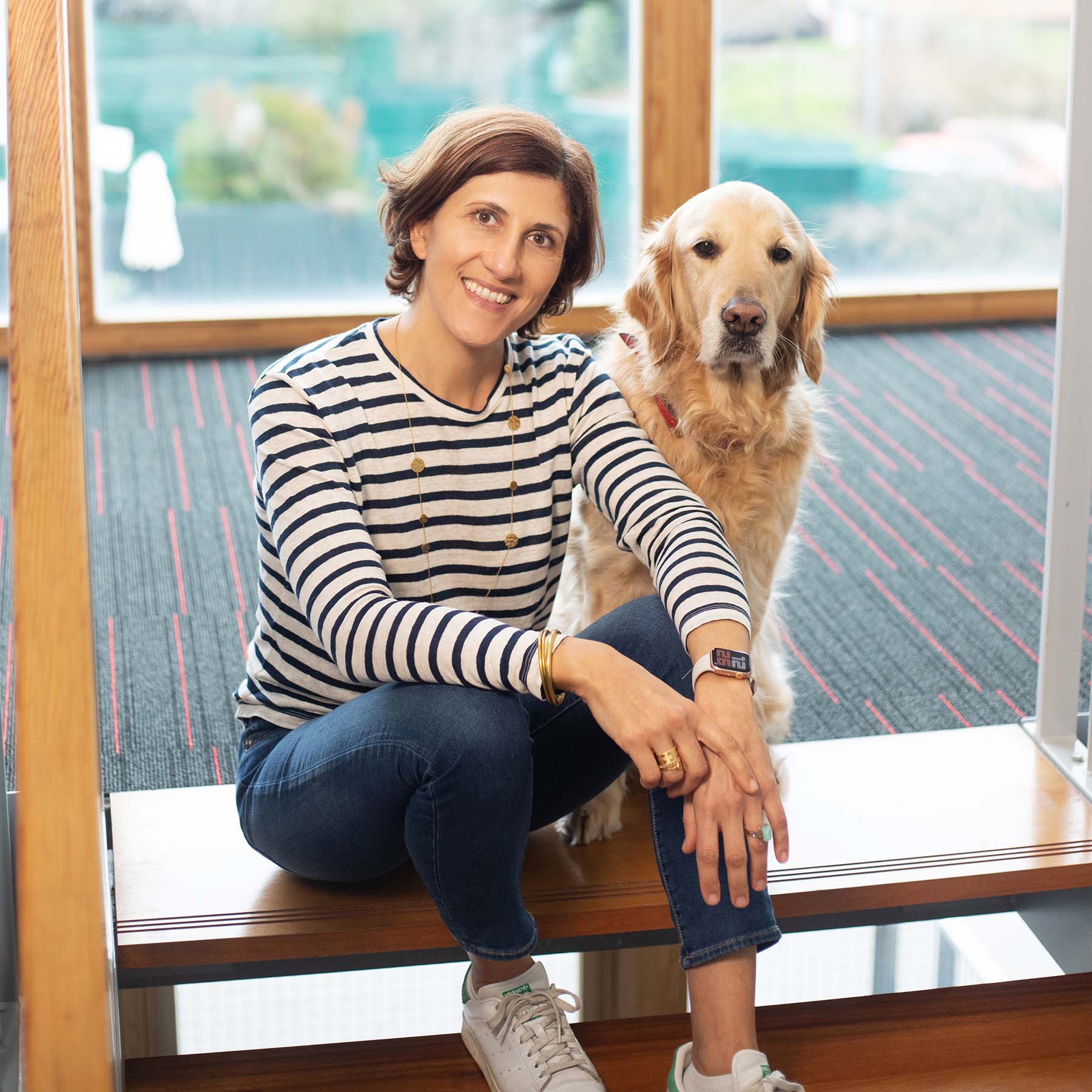 Diane Schakowskoy et Maika, la mascotte d'Agent de Com, assises en haut d'un escalier.